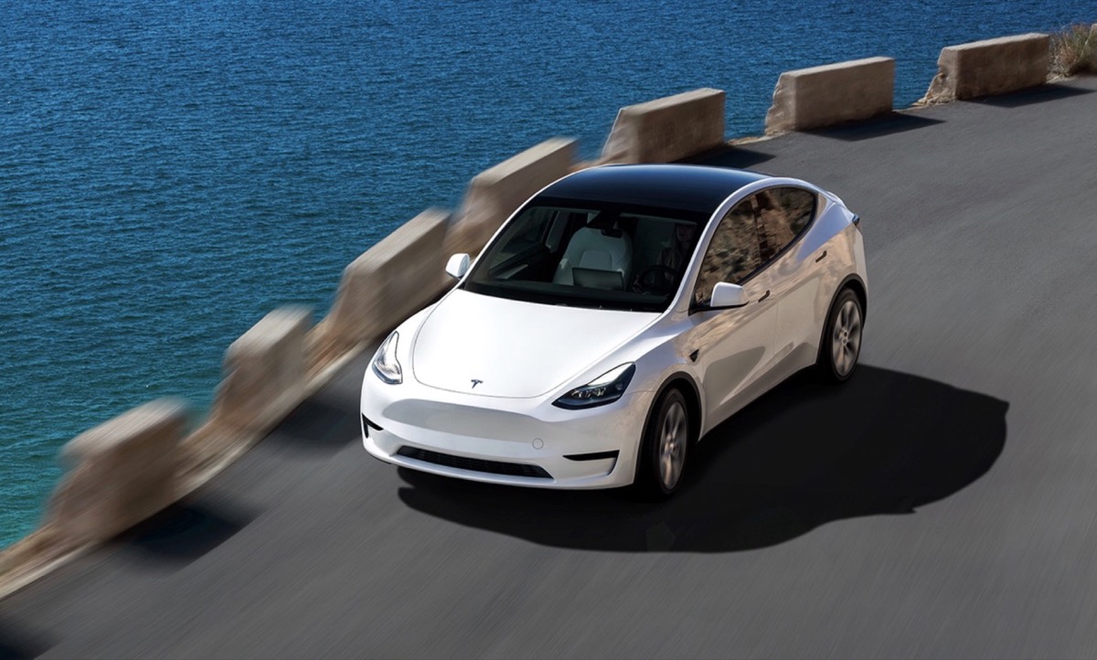 White Tesla Model Y on a coastal road